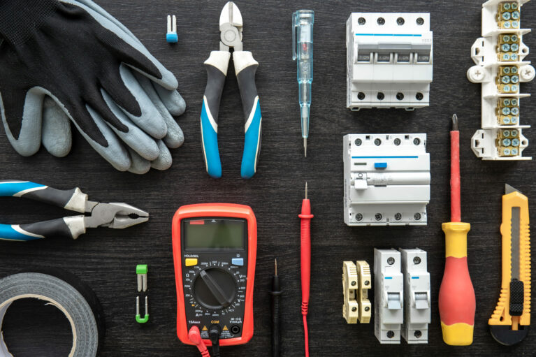 Flat lay composition with electrical tools on wooden background.