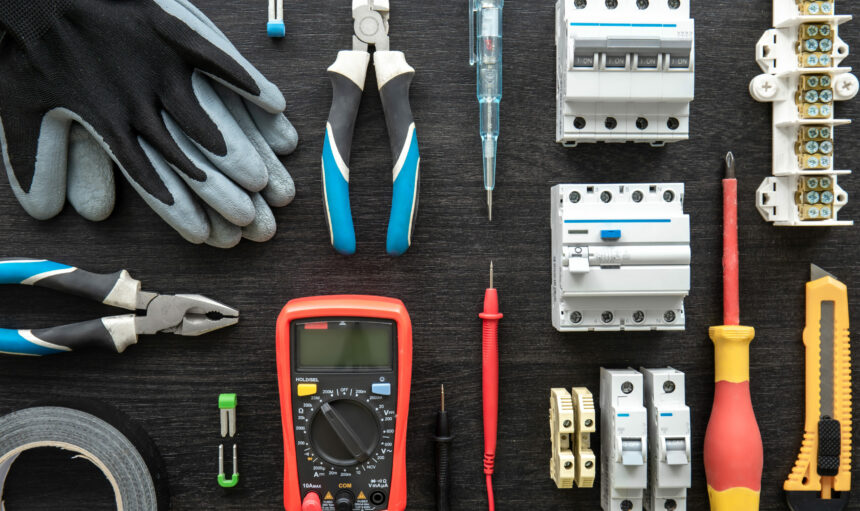 Flat lay composition with electrical tools on wooden background.